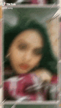 a blurry picture of a woman 's face with the words tiktok written on the bottom