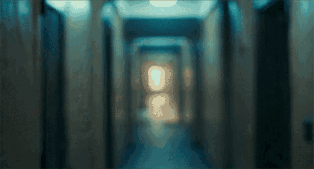 a dark hallway with a few lights on the walls