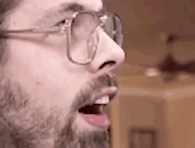 a close up of a man with a beard and glasses .