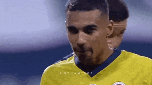 a soccer player in a yellow shirt is making a funny face