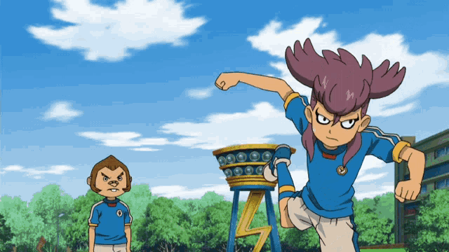a boy in a blue shirt with the letter o on it is standing next to a monkey