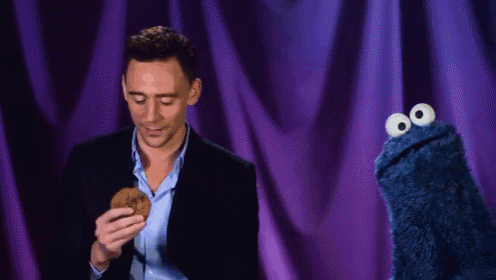 a man is eating a cookie next to a cookie monster .