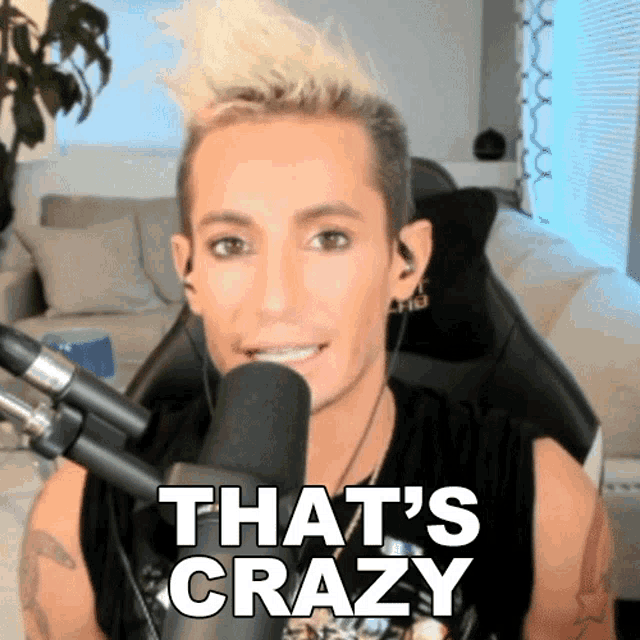 a man sitting in front of a microphone with the words that 's crazy above him