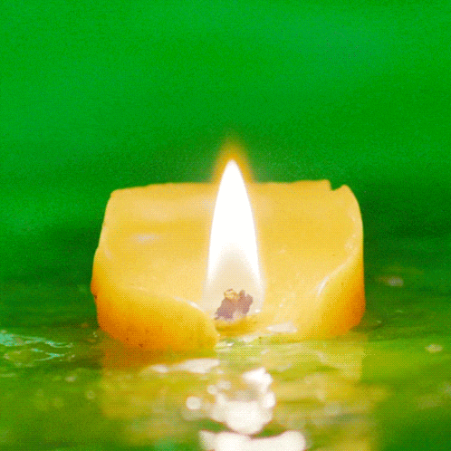 a yellow candle with a flame is floating in the water