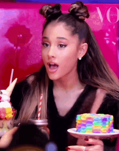 ariana grande is holding a plate of rainbow pancakes and a drink