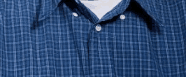 a man is wearing a blue plaid shirt and a white shirt underneath .