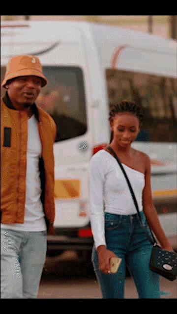 a man and a woman walking in front of a van