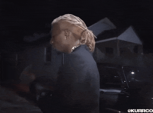 a man with dreadlocks is wearing earrings and a black jacket