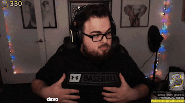 a man wearing headphones and a black under armour baseball shirt is on a twitch stream