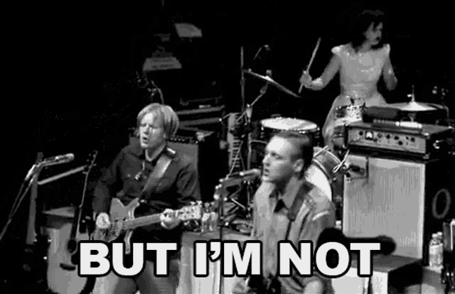 a black and white photo of a band playing music on a stage .