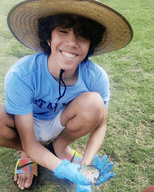 a young boy wearing a hat and a blue shirt that says ' texas ' on it