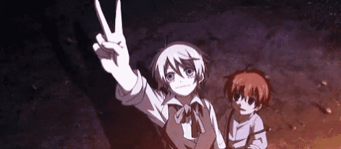 a boy is giving a peace sign while standing next to another boy in a dark room .
