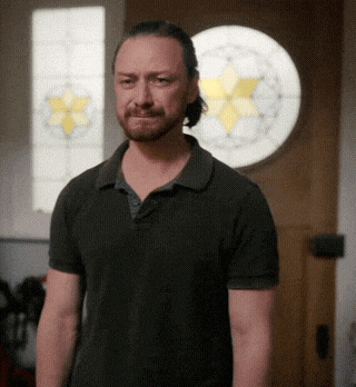 a man in a black shirt is standing in front of a stained glass door