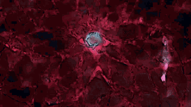 a close up of a red and black background with a circle in the middle .