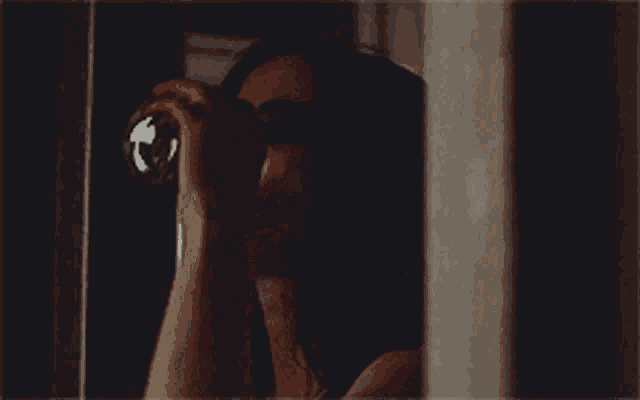 a woman is drinking from a glass in the dark