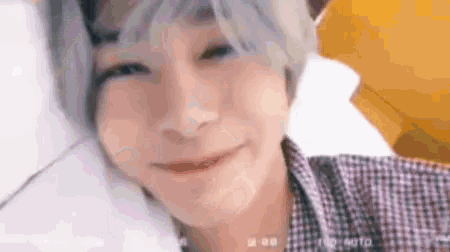 a close up of a person 's face while laying on a bed and smiling .