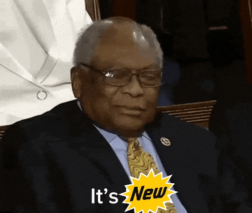 a man in a suit and tie with a yellow sticker that says " it 's new "