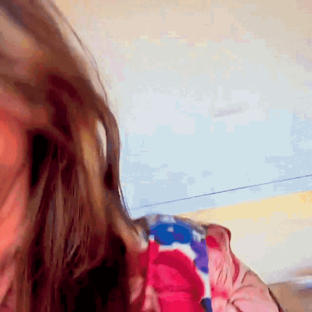 a close up of a woman 's face with a floral shirt