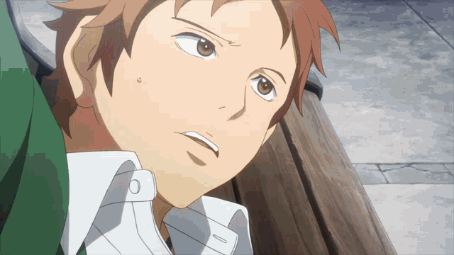 a close up of a man 's face with a white shirt and brown hair