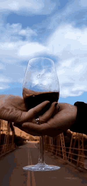 a person holding a wine glass that says ' jc ' on the glass