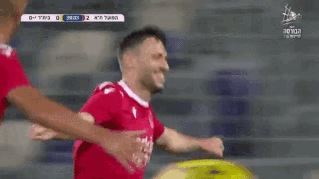 a soccer player wearing a red shirt that says arkit on it