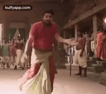 a man is dancing in front of a crowd of people .