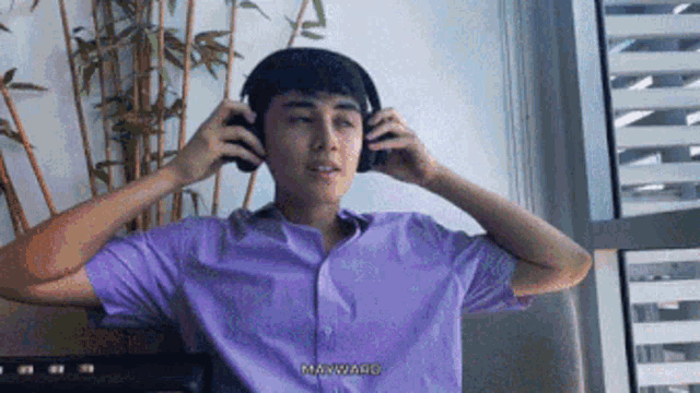 a man in a purple shirt is wearing headphones and says marwao