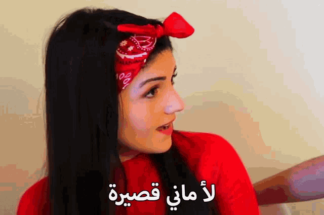 a woman wearing a red shirt and a red headband with arabic writing