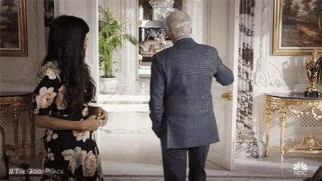 a man in a suit is standing next to a woman in a floral dress .