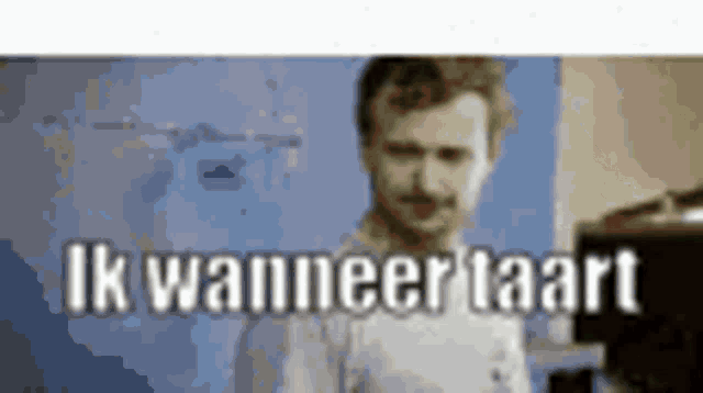 a man in a white shirt is standing in front of a blue wall with the words ik wanneertaart written in white letters .