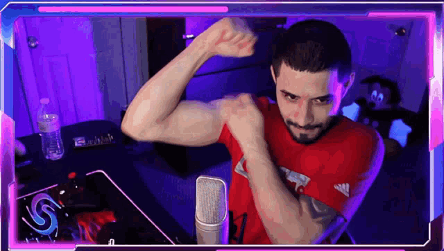 a man flexing his muscles in front of a microphone
