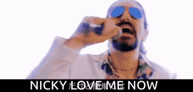 a man wearing sunglasses is singing into a microphone with the words " nicky love me now " above him