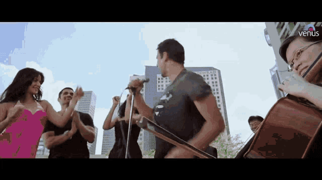 a group of people are dancing in front of a man playing a guitar and cello ..