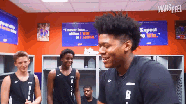 a group of basketball players are standing in a locker room with a sign that says expect to win
