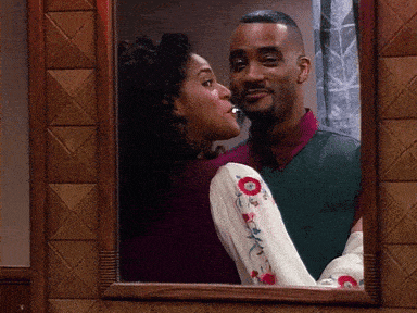 a man and a woman are kissing in a mirror