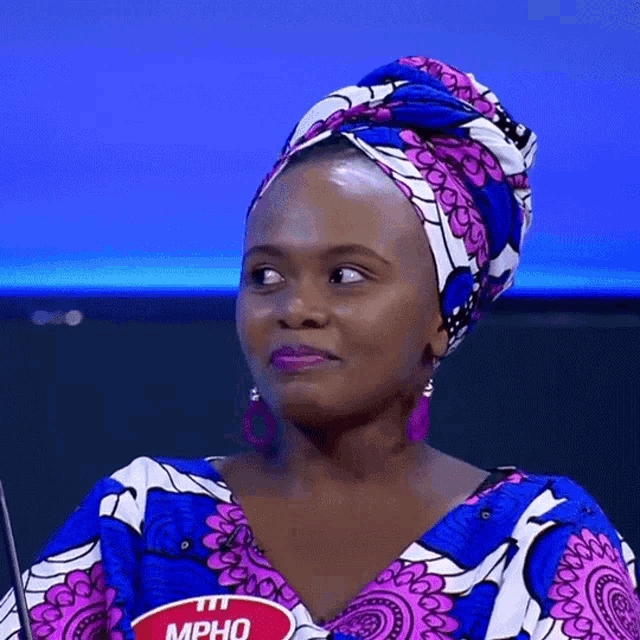 a woman wearing a head scarf has a name tag that reads mpho