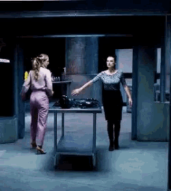 two women are standing next to each other in a room