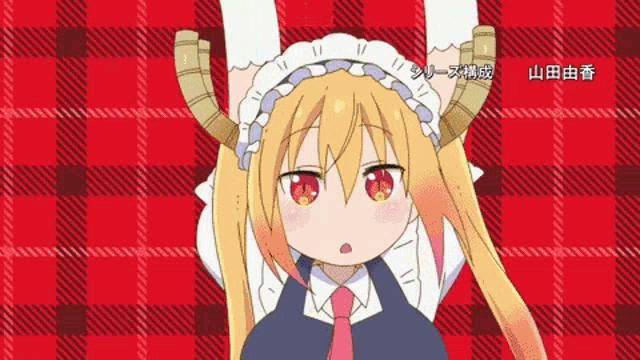 a girl with horns is hanging upside down on a red plaid background .