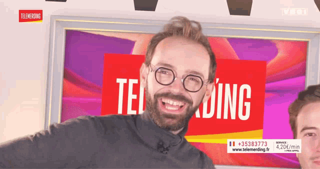 a man with glasses is smiling in front of a sign that says telemarketing