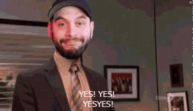 a man with a beard is smiling and saying yes ! yes ! yes ! yes !