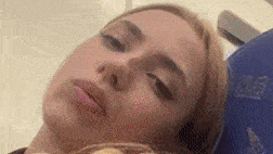 a close up of a woman 's face with her eyes closed and a blurred background .