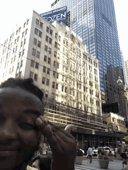 a man is taking a picture of himself in front of a building that has a frozen sign on it