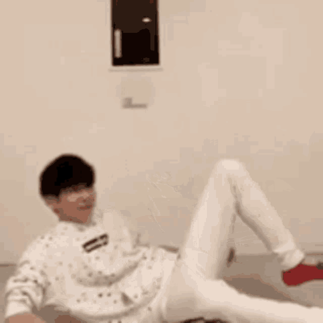 a man is laying on the floor with his legs up