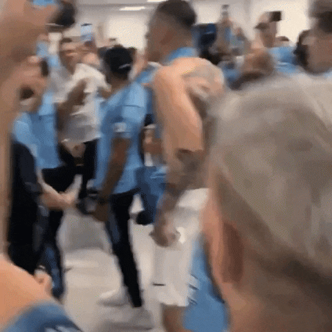 a group of people are standing in a room and dancing .