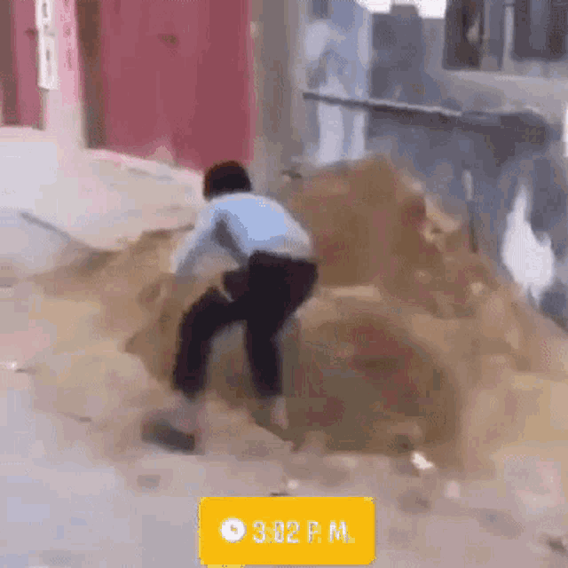 a man is standing on a pile of dirt with a time of 3:02 p.m.