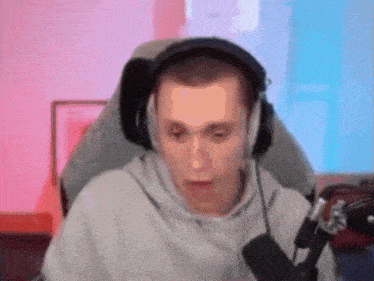 a man wearing headphones and a microphone is sitting in front of a microphone .