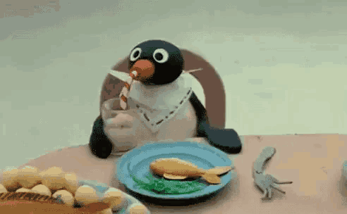 a cartoon penguin is sitting at a table with a plate of food and the words cia be written on the bottom