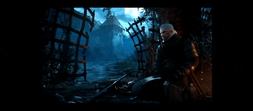 a man with a sword is sitting in the dark