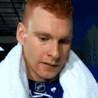 a man with a towel around his neck is wearing an nhl shirt