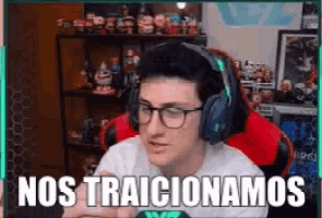 a man wearing headphones and glasses is sitting in front of a computer screen that says nos traicionamos .